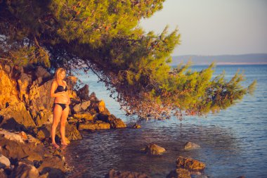 Bikini hamile kadın günbatımında sakin ol