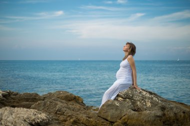 Sahilde hamile bir kadın.