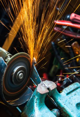 İşçi değirmeni ile metal kesme. Demir taşlama sırasında yol açtı. S