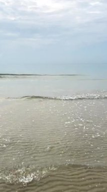 Gündüz vakti bulutlu gökyüzü ile okyanus dalgalarının dikey görüntüsü