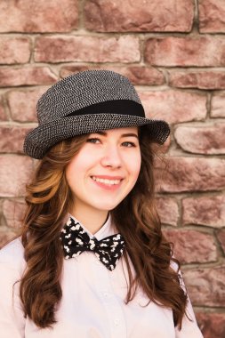 Bir model bir şapka bir tuğla duvarın üzerinden portresi