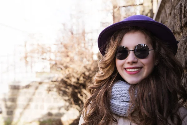 Portrait of a model wearing sunglasses, scarf and  jacket over a — Stock Photo, Image