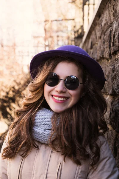 Portrait of a model wearing sunglasses, scarf and  jacket over a — Stock Photo, Image