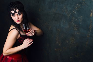 bir bardak kırmızı şarap tutan güzel esmer kadın