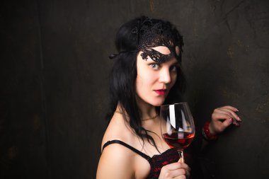 bir bardak kırmızı şarap tutan güzel esmer kadın