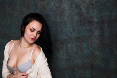 Stüdyo portre bir seksi esmer gri iç çamaşırı ve beyaz hırka