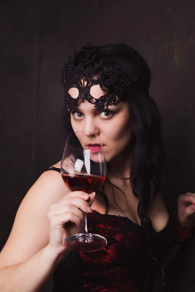 Bela mulher morena segurando um copo de vinho tinto — Fotografia de Stock