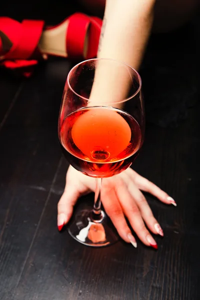 Mãos de mulher segurando um copo de vinho — Fotografia de Stock