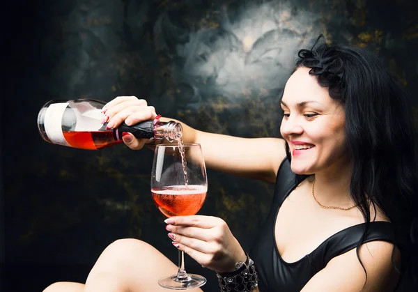 Красива молода сексуальна жінка в чорній білизні тримає пляшку вина — стокове фото