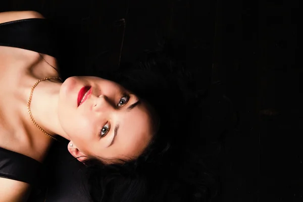 Portret piękna brunetka czarowny leżącego na podłodze w studio — Zdjęcie stockowe