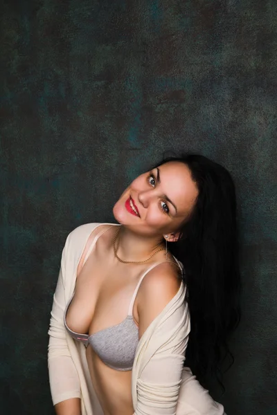 Studio portrait of a sexy brunette in grey lingerie and white cardigan — Stock Photo, Image