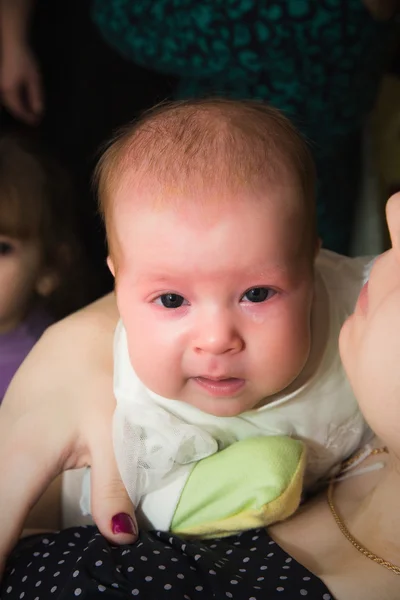 Llorando bebé en la madre manos mirando a la cámara —  Fotos de Stock