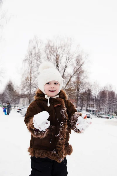 Kleines Mädchen spielt im Winter mit Schnee — Stockfoto