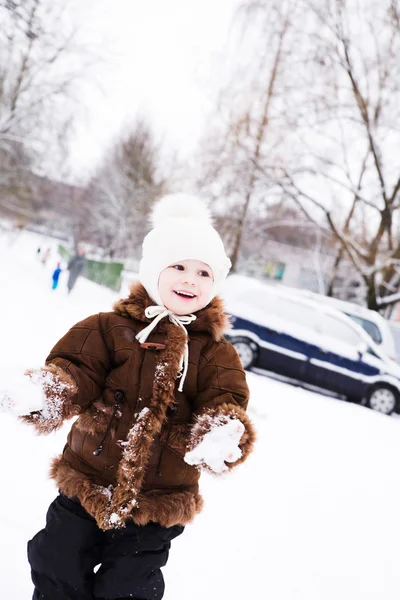 Kleines Mädchen spielt im Winter mit Schnee — Stockfoto