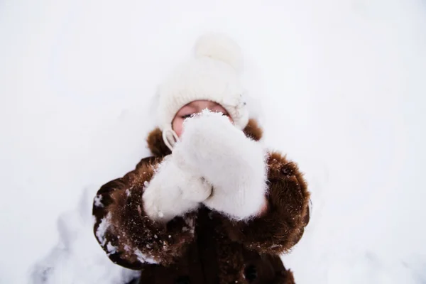 Szczęśliwe dziecko dziewczynka w śniegu na sobie białe rękawiczki — Zdjęcie stockowe