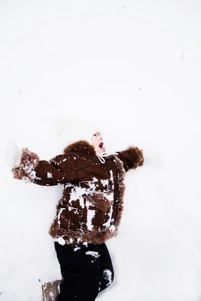 Szczęśliwe dziecko dziewczynka w śnieg na zewnątrz w zimie — Zdjęcie stockowe