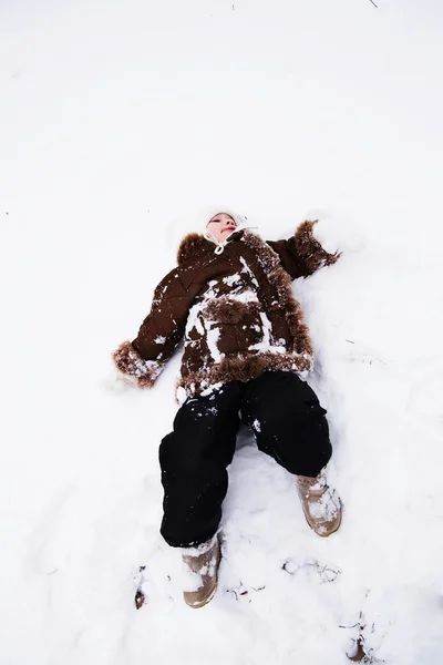 Szczęśliwe dziecko dziewczynka w śnieg na zewnątrz w zimie — Zdjęcie stockowe