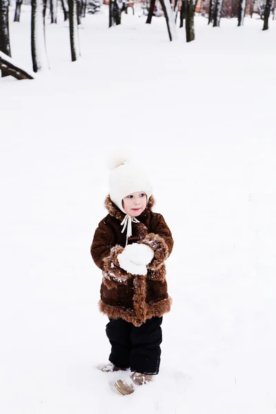 Kleines Mädchen spielt im Winter mit Schnee — Stockfoto