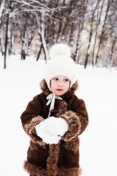 Kleines Mädchen spielt im Winter mit Schnee — Stockfoto
