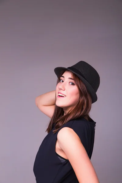 Örömteli szép lány visel a fekete ruhát és fekete klasszikus kalap smi — Stock Fotó