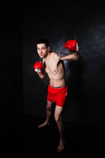Karanlık odada kırmızı eldivenli boksör — Stok fotoğraf