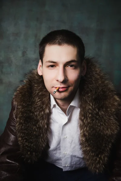 Portret przystojny mężczyzna w futra z papierosem — Zdjęcie stockowe