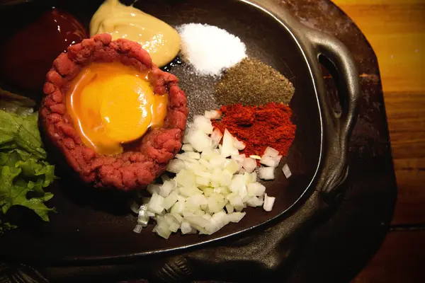 Tartar de ternera fresca con huevo, adobado con especias, cebolla, ketchup — Foto de Stock