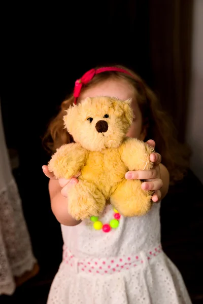 A menina guarda um urso de brinquedo — Fotografia de Stock