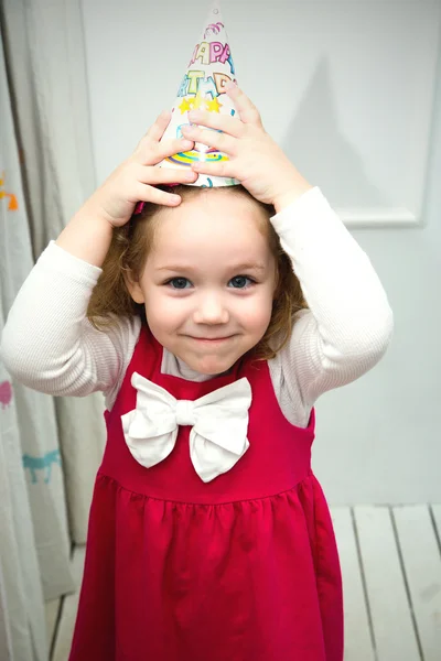 Menina engraçada em boné de aniversário — Fotografia de Stock