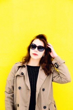 Sarı arka plan üzerinde ceket giyen kız