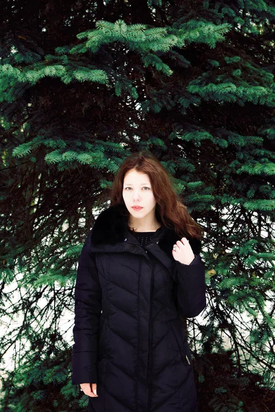 전나무 나무의 배경에서 아름 다운 여자 — 스톡 사진