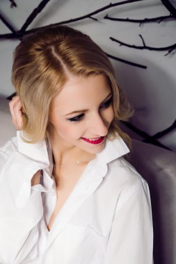 Beyaz gömlek giymiş, rahatlatıcı sevimli sarışın kadın portresi. Lon