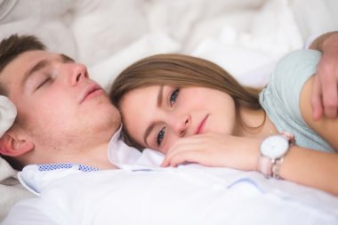 Genç çift yatakta seviyorum. Kız çocuğun omzuna yalan