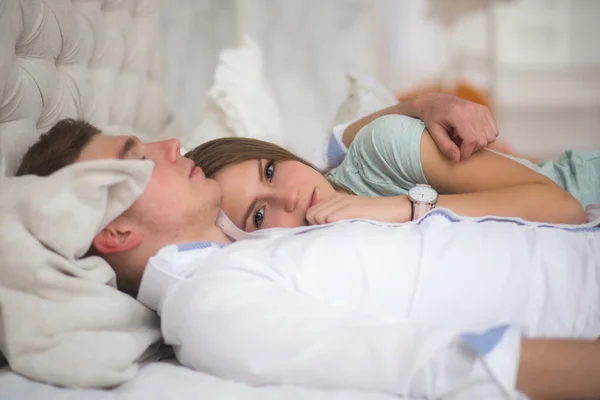 Young love couple in bed. Girl lying on the boy's shoulder