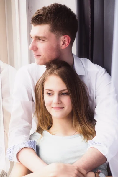 Young couple enjoying themselves on the windowsill — Stock Photo, Image