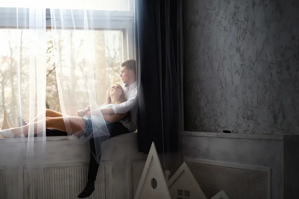 Молодая пара наслаждается жизнью на подоконнике — стоковое фото