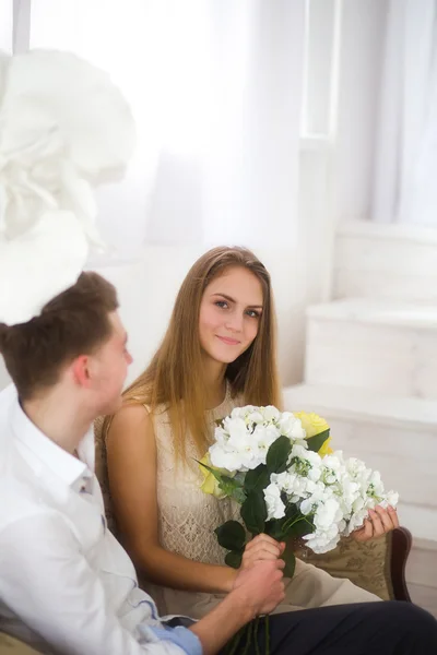 Bonita pareja joven sentada en el sofá — Foto de Stock