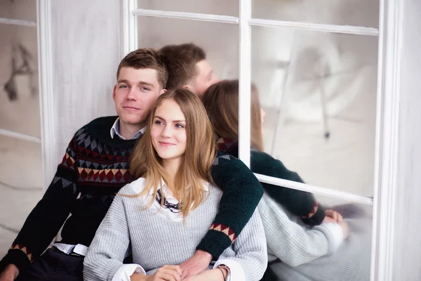 Couple d'adolescents assis contre le mur miroir — Photo