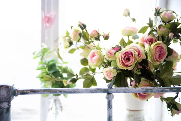 Куча красивых искусственных розовых цветов на окне — стоковое фото