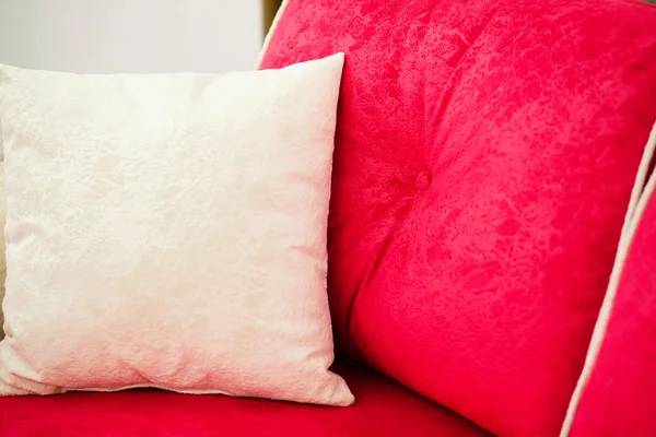 Dekorační polštáře na červené pohovce — Stock fotografie