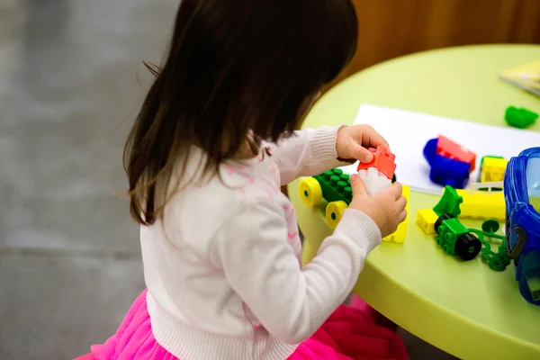 Charmoso pré-escolar brincando com pequeno construtor — Fotografia de Stock