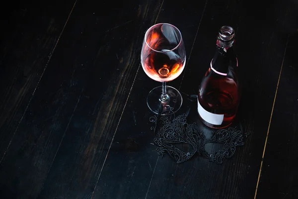 Butelka czerwonego wina na drewnianym stole — Zdjęcie stockowe