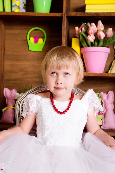 Ragazza carina seduta sulla sedia in camera — Foto Stock