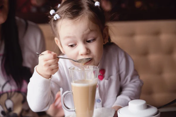 Little girl try to drink coffee — Stock Photo, Image