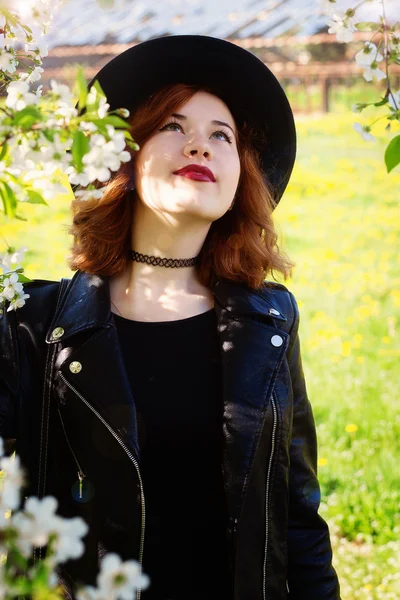 Girl in a hat enjoy spring flowers — Stock Photo, Image