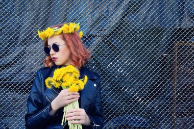 Kız bir siyah ceket ve karahindiba bir buket ile şapka