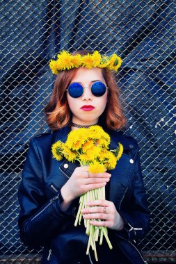 Kız bir siyah ceket ve karahindiba bir buket ile şapka