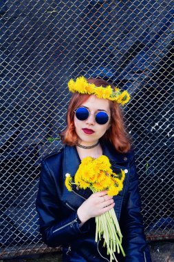 Kız bir siyah ceket ve karahindiba bir buket ile şapka