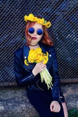 Kız bir siyah ceket ve karahindiba bir buket ile şapka