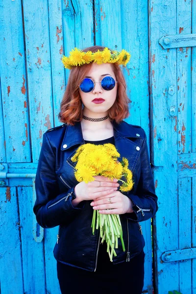 Kız bir siyah ceket ve karahindiba bir buket ile şapka